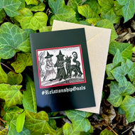 A black coloured card featuring a mediaeval woodcut artwork depicting two witches, one of which is holding a pet demon. Beneath it the caption reads #RelationshipGoals. Pictured with a brown envelope, and resting on a bed of ivy.