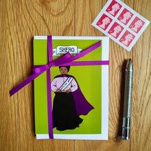Load image into Gallery viewer, Photo of the pack, bound with purple ribbon. The Shero card and white envelope is on the top. Next to the card pack is a silver pen and six first-class stamps.