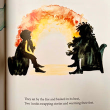Load image into Gallery viewer, Photo of a page in the book. Two seated figures are silhouetted and facing each other with the light of the fire between them. The smaller has a beard. The larger seems to have a wild beard and wild animated hair.