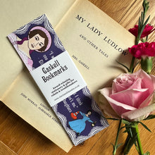 Load image into Gallery viewer, Set off bookmarks With paper band around the middle saying “Gaskell bookmarks”, Displayed on an open copy of a book by Elizabeth Gaskell and next to pink flowers