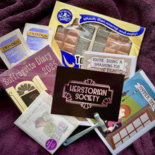 Load image into Gallery viewer, Photo of an array of Clavis and Claustra products, including the suffragette diary, suffragette bookplates set, smashing job card, Hammer time card, along with two twinings inner clarity tea bags and a gift set of walkers non-such toffee with a toffee hammer. In the centre is a card displaying the herstorian Society logo, and another toffee Hammer.