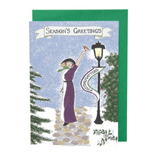 Load image into Gallery viewer, Photo of a card showing Emily Davison in a purple and white dress with a black hood. She stands on a path surrounded by snow and an old-fashioned lamppost. She has a raised arm, with a robin at rest on her fingers. From the lamppost is a banner that says “#VOTINGMATTERS”. The main caption says “Season’s Greetings” on a banner. The card is on top of a green envelope.