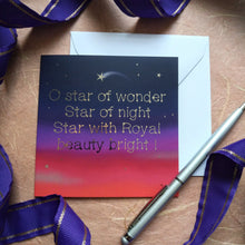 Load image into Gallery viewer, Photo of a card showing the night sky and sunset in colours from deep red to purple and stars against dark blue. A shooting star is among all the others. The text, in gold type, reads “O star of wonder Star of night Star with Royal beauty bright!”. Next to the card is a white envelope, silver pen, and a curling purple ribbon.