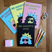 Load image into Gallery viewer, Photo of Her Majesty’s Doodles notebook, alongside Her Majesty’s Ideas, Her Majesty’s Jottings, and Her Majesty’s Notes books in similar styles. Next to these are some gift tape, felt tip pens, and a stack of sticky notes.