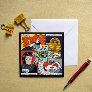 Photo of the card on a white envelope. The image is divided in four, showing a woman with giant red hair and holding a spear (“Boudicca, slayin’”); a pharaoh (“Hatshepsut, stone-cold boss”) scowling as someone out of shot shouts “Nice lady-beard!”; Queen Victoria with a thought bubble that says “We are not amused!” (“Queen Vic, throwing shade”); and Mary, Queen of Scots and Queen Elizabeth I scowling and butting heads (“QE1 vs MQS, Dames of Thrones”). Next to the card is a document clip and red pen.