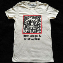 Load image into Gallery viewer, Photo of a white t-shirt featuring a mediaeval woodcut artwork depicting witches and demons joining hands and dancing in a circle, framed by a thin red border. Beneath it the caption reads &#39;Hex, drugs &amp; mind control&#39;.