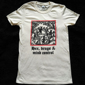 Photo of a white t-shirt featuring a mediaeval woodcut artwork depicting witches and demons joining hands and dancing in a circle, framed by a thin red border. Beneath it the caption reads 'Hex, drugs & mind control'.