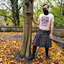 Load image into Gallery viewer, Photo of a white man outside with one hand against a tree. He wears a black kilt with black shoes and socks, black sunglasses and a black face mask, along with a t-shirt featuring a mediaeval woodcut artwork depicting witches and demons joining hands and dancing in a circle, framed by a thin red border. Beneath it the caption reads &#39;Hex, drugs &amp; mind control&#39;. Autumn leaves carpet the ground.