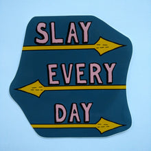 Load image into Gallery viewer, Photo of a dark blue sticker that says “Slay Every Day” in pink text, with each word underlined by spears.