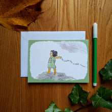 Load image into Gallery viewer, The card in green: a girl in yellow boots and a green coat and yellow scarf standing on the moors, as the wind blows through her dark hair. Behind her is the caption “No coward soul is mine - Emily Bronte”. Next to the cards are some autumn leaves and a felt tip pen.