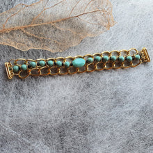 Load image into Gallery viewer, Photo of the bracelet, consisting of golden links that interweave with turquouise beads. The necklace is not joined and is laid flat.