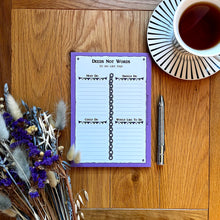 Load image into Gallery viewer, A photo of a notepad with a pen, a bunch of dried flowers and a cup of black tea. The pad has a purple border and is entitled &#39;Deeds Not Words&#39; with the page sectioned off into &#39;Must do&#39;, &#39;Should do&#39;, &#39;Could do&#39; and &#39;Would like to do&#39;, decorated with chains and bunting.